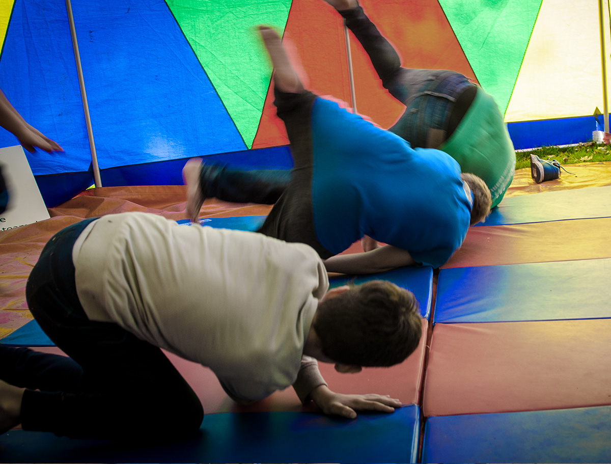 Jungen rollen sich auf bunten Matten ab