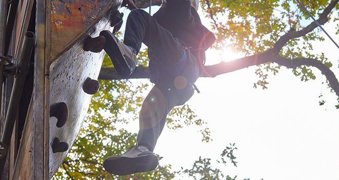 Ein junger Mann klettert eine Kletterwand hoch