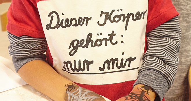 Ein Junge, auf dessen Pullover der Satz 'Mein Körper gehört nur mir' steht