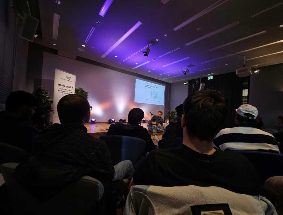 Zuhörende folgen einem Vortrag